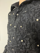 Pearl Cendre Shirt — close crop of the button placket, deeply crinkled black relief surface with pearlescent buttons and cream half-pearls
