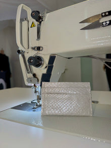 Cardholder salmon leather white — the silver cardholder standing on the bed of an industrial sewing machine in the atelier