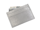 Cardholder salmon leather white — the silver cardholder tilted against white with banknotes tucked into the top slot