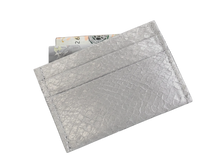 Cardholder salmon leather white — the silver cardholder tilted against white with banknotes tucked into the top slot