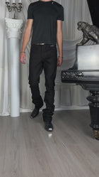Bootcut Denim — video, model in a black T-shirt walking past a white column and a piano