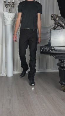 Bootcut Denim — video, model in a black T-shirt walking past a white column and a piano